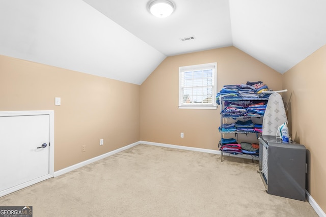 additional living space featuring lofted ceiling and light carpet