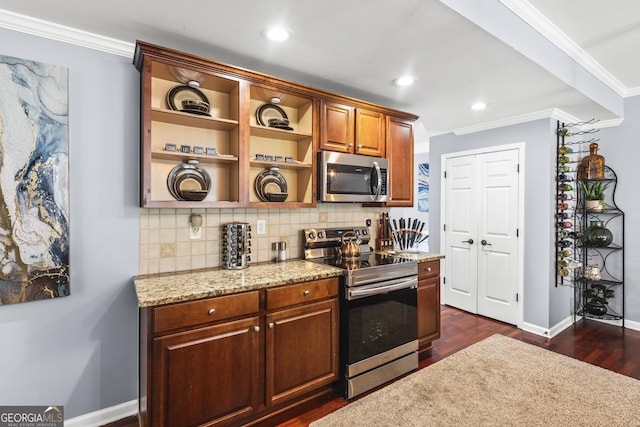 kitchen with light stone countertops, dark hardwood / wood-style floors, backsplash, appliances with stainless steel finishes, and ornamental molding