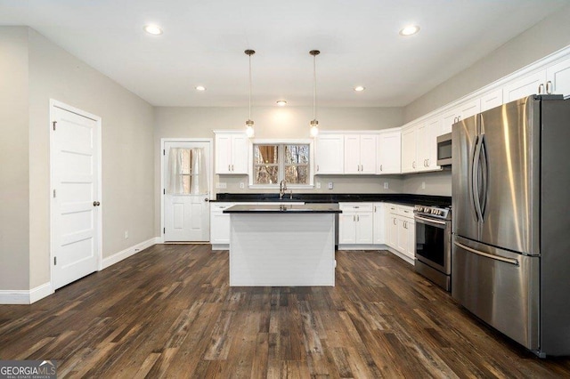 kitchen with white cabinets, hanging light fixtures, dark hardwood / wood-style floors, a kitchen island, and appliances with stainless steel finishes