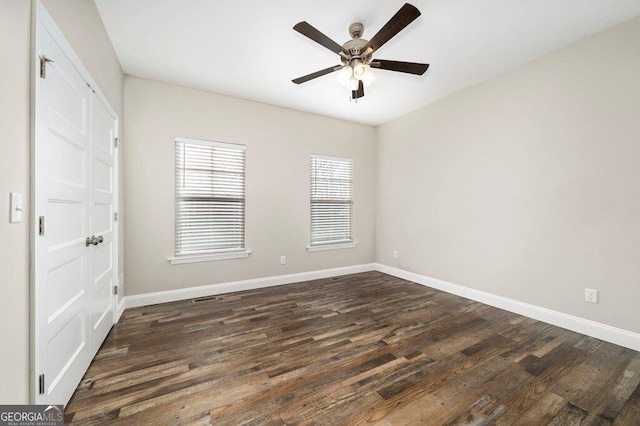 unfurnished bedroom with ceiling fan and dark wood-type flooring