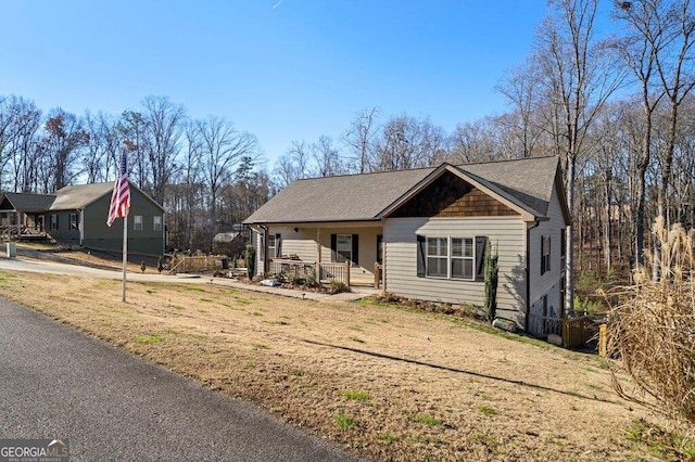 view of front of property featuring covered porch and a front lawn