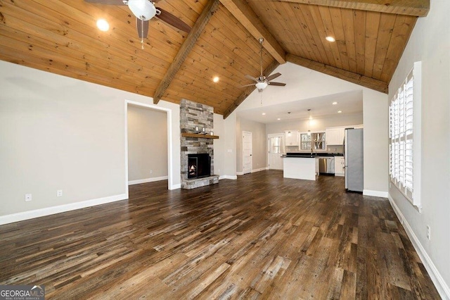 unfurnished living room with beamed ceiling, a fireplace, wood ceiling, and dark hardwood / wood-style floors