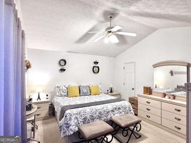 bedroom featuring lofted ceiling, light carpet, a textured ceiling, and ceiling fan