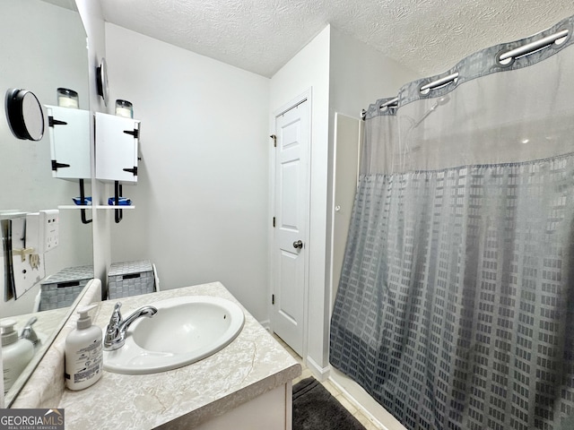 bathroom with vanity, a textured ceiling, and a shower with curtain