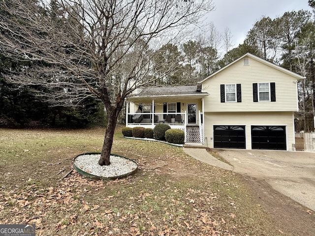 split level home with a garage, covered porch, and a front yard