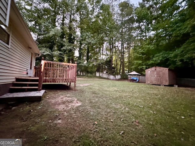 view of yard featuring a deck and a storage unit