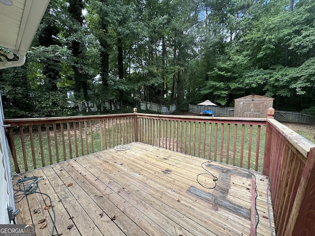 wooden deck featuring a storage unit and a lawn