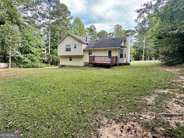 rear view of property featuring a yard and a deck