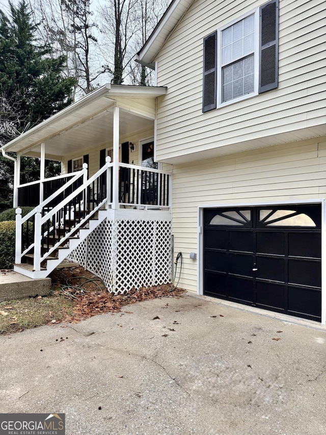 view of side of home featuring a garage and covered porch