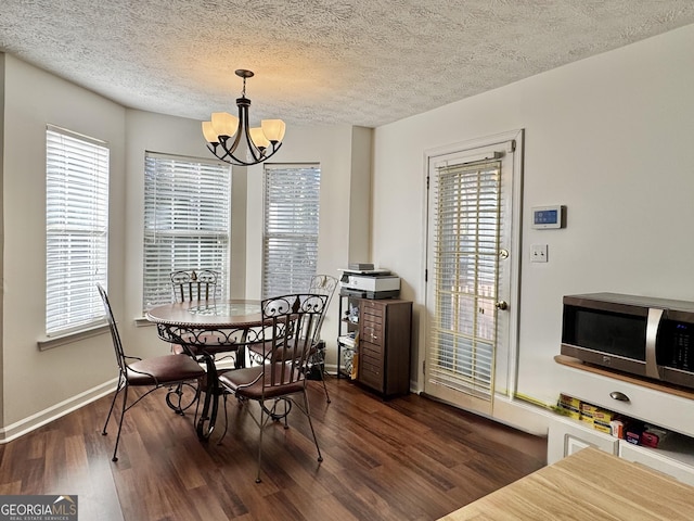 dining space with an inviting chandelier, dark hardwood / wood-style floors, and a healthy amount of sunlight