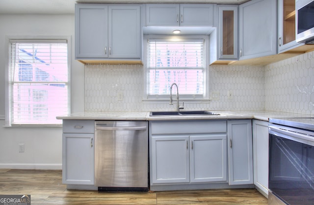 kitchen with appliances with stainless steel finishes, light hardwood / wood-style floors, and sink