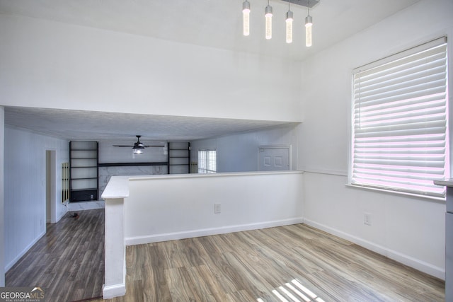 unfurnished room featuring ceiling fan with notable chandelier and hardwood / wood-style floors