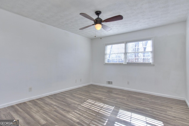 spare room with a textured ceiling, ceiling fan, and light hardwood / wood-style flooring