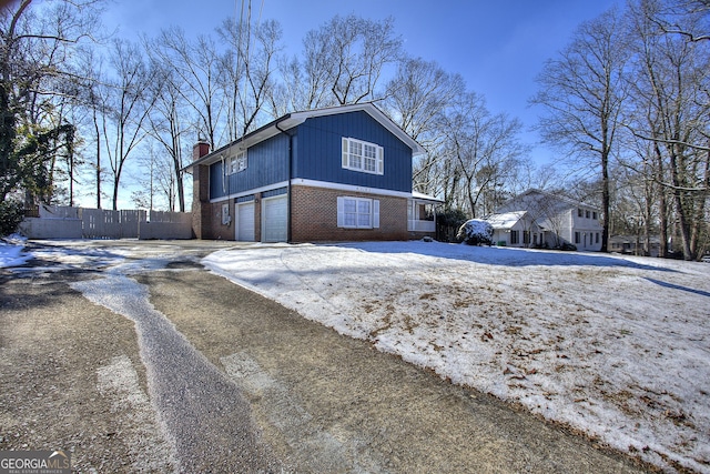 view of snow covered exterior with a garage