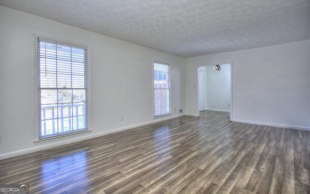 unfurnished room featuring a textured ceiling and dark wood-type flooring