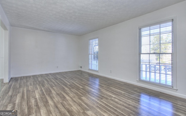 unfurnished room with a textured ceiling and hardwood / wood-style floors