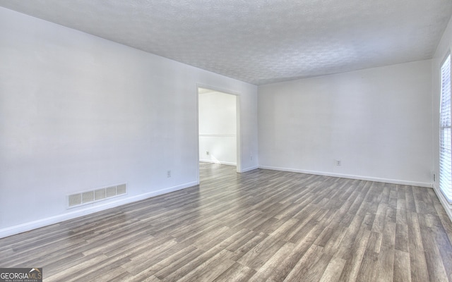 unfurnished room with a textured ceiling and hardwood / wood-style flooring