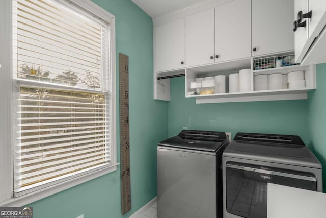 washroom with washer and dryer, a wealth of natural light, and cabinets