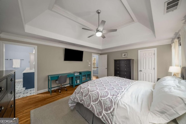 bedroom with hardwood / wood-style flooring, ceiling fan, a tray ceiling, and ensuite bathroom