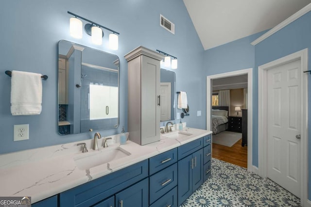 bathroom with lofted ceiling, tile patterned flooring, walk in shower, and vanity