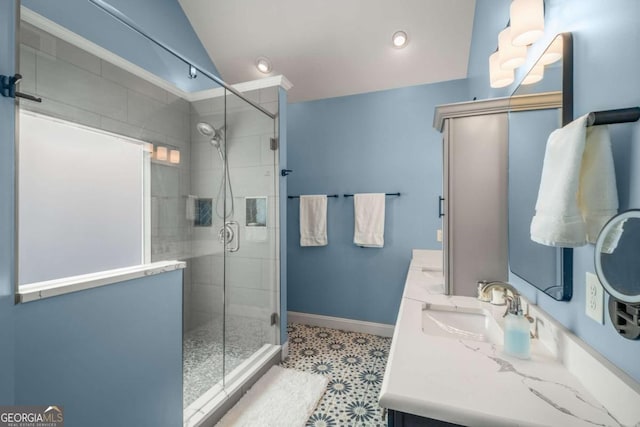 bathroom featuring vaulted ceiling, an enclosed shower, and vanity