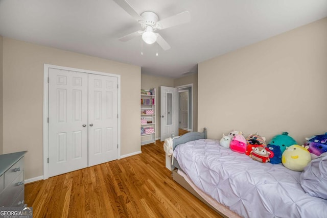 bedroom featuring ceiling fan, light hardwood / wood-style flooring, and a closet