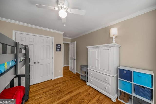 bedroom with a closet, ceiling fan, crown molding, and light hardwood / wood-style flooring