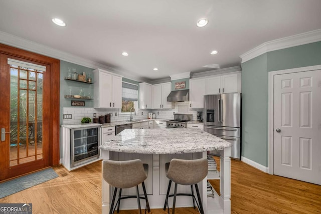 kitchen featuring premium appliances, a kitchen island, wine cooler, and white cabinetry