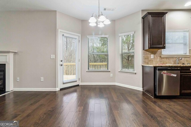 kitchen with tasteful backsplash, stainless steel dishwasher, light stone countertops, and dark brown cabinets