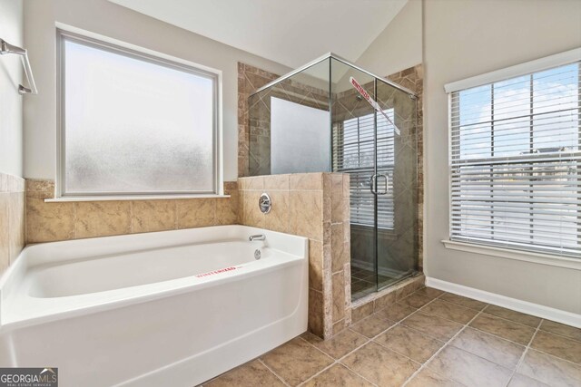 bathroom featuring lofted ceiling, independent shower and bath, tile patterned floors, and plenty of natural light