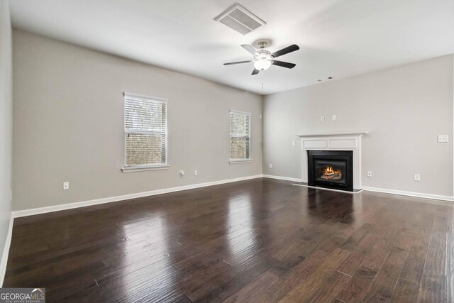 unfurnished living room with ceiling fan and dark hardwood / wood-style flooring