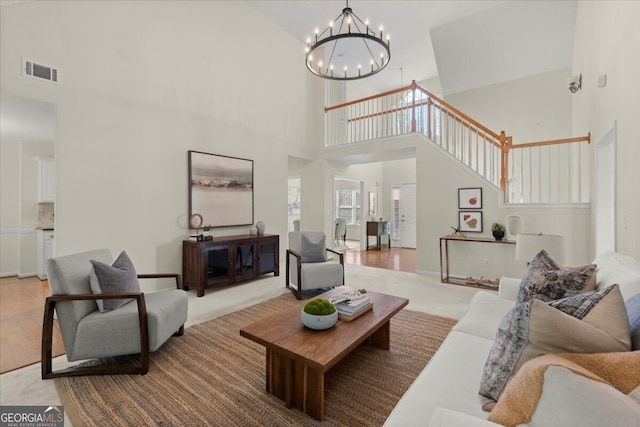 living room with a towering ceiling and a chandelier