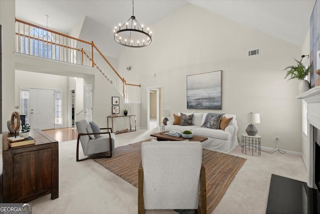 living room featuring high vaulted ceiling, a notable chandelier, and light carpet