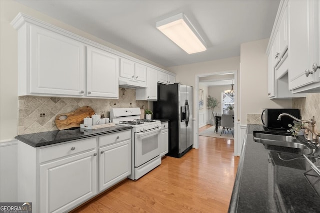 kitchen featuring white cabinets, white range with gas cooktop, stainless steel refrigerator with ice dispenser, and sink