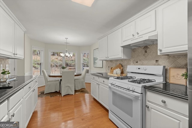 kitchen featuring white cabinets, a notable chandelier, decorative light fixtures, and white gas range