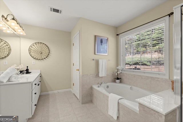 bathroom with a relaxing tiled tub, tile patterned floors, and vanity