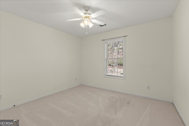 carpeted spare room with ceiling fan