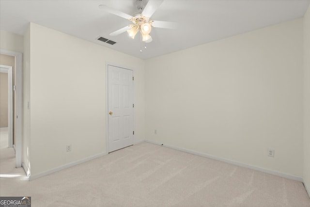 carpeted spare room featuring ceiling fan