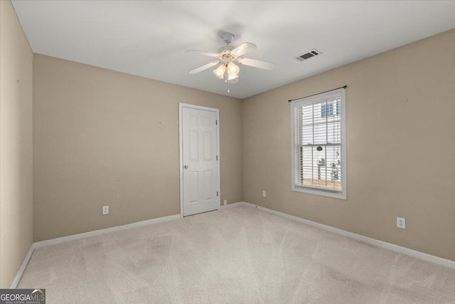 carpeted spare room with ceiling fan