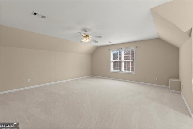 additional living space featuring ceiling fan, vaulted ceiling, and light carpet