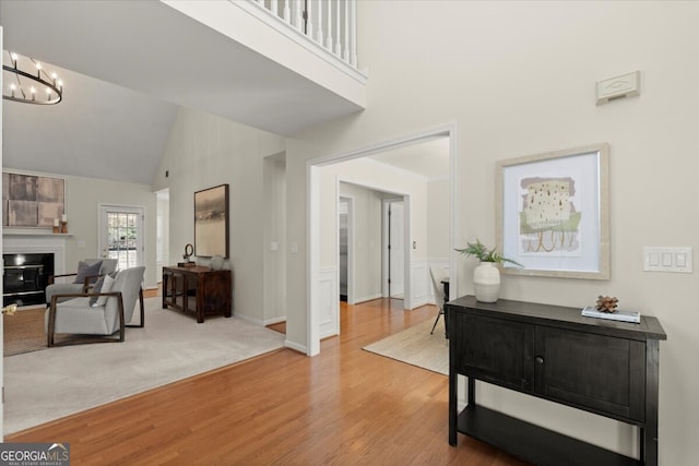 entrance foyer featuring high vaulted ceiling, light hardwood / wood-style flooring, and a chandelier