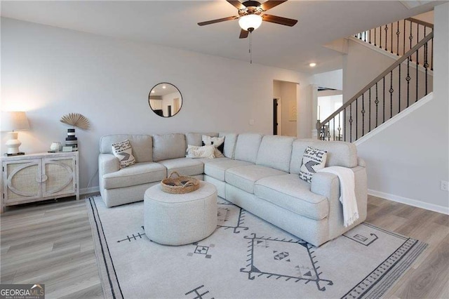 living room featuring ceiling fan and light hardwood / wood-style flooring