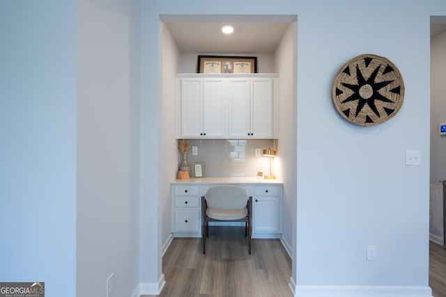 office area with built in desk and light hardwood / wood-style floors