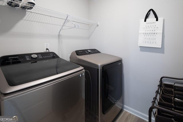 laundry room featuring hardwood / wood-style flooring and washing machine and dryer