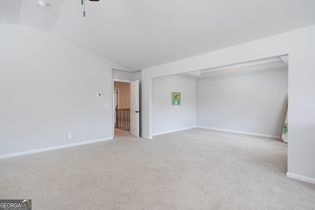 spare room featuring lofted ceiling and light carpet