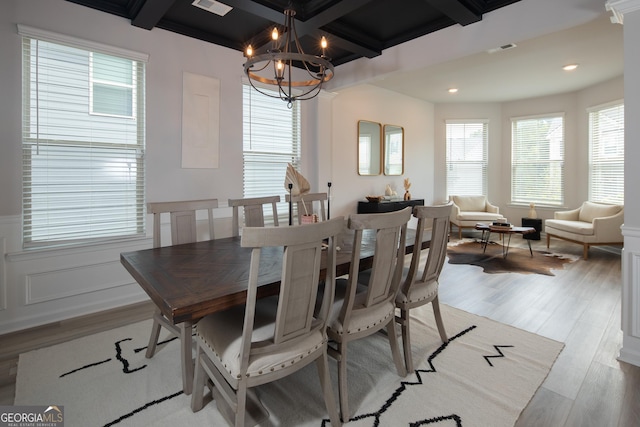 dining space featuring beam ceiling, a chandelier, and light wood-type flooring