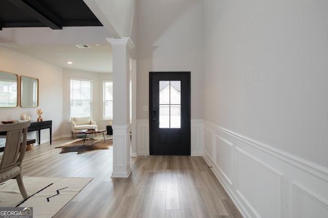 foyer with light hardwood / wood-style flooring and ornate columns