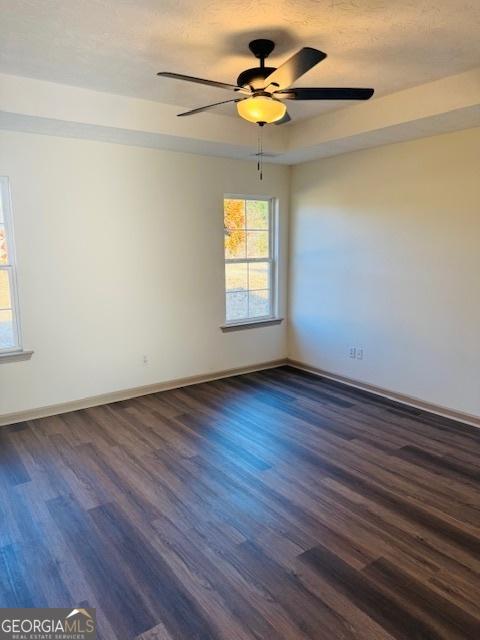 empty room featuring dark wood-type flooring and ceiling fan