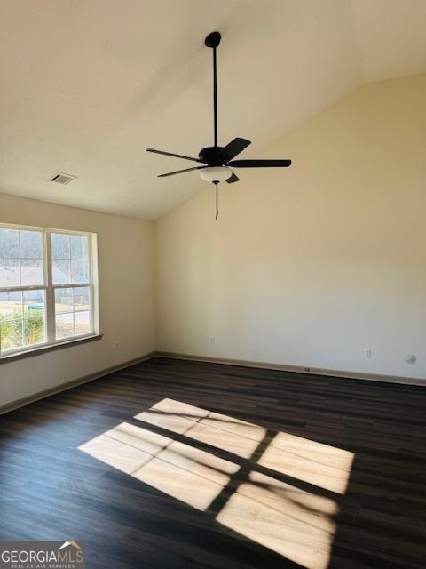 spare room featuring lofted ceiling, dark hardwood / wood-style flooring, and ceiling fan