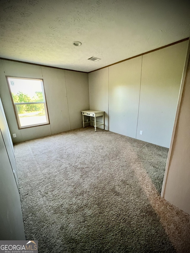 empty room with a textured ceiling and carpet